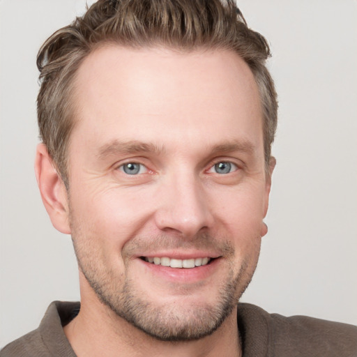 Joyful white adult male with short  brown hair and grey eyes