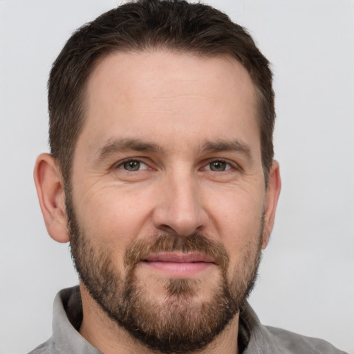 Joyful white adult male with short  brown hair and brown eyes