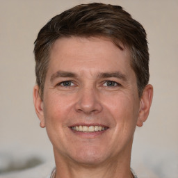 Joyful white adult male with short  brown hair and grey eyes