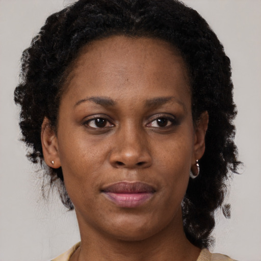 Joyful black adult female with medium  brown hair and brown eyes