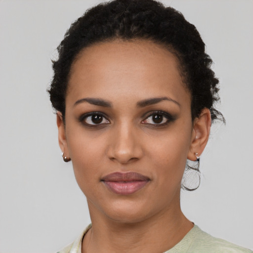 Joyful black young-adult female with short  black hair and brown eyes