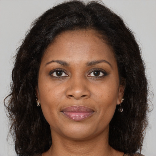 Joyful black adult female with long  brown hair and brown eyes