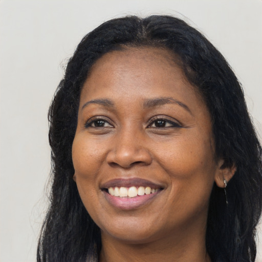 Joyful black adult female with long  black hair and brown eyes