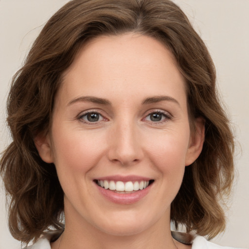 Joyful white young-adult female with medium  brown hair and green eyes