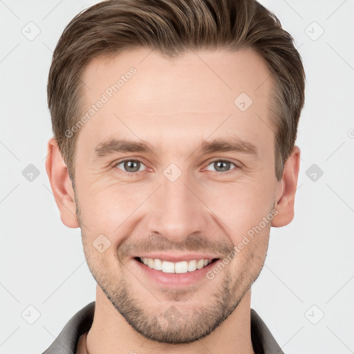 Joyful white young-adult male with short  brown hair and grey eyes