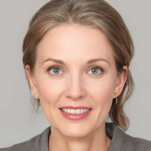 Joyful white adult female with medium  brown hair and grey eyes