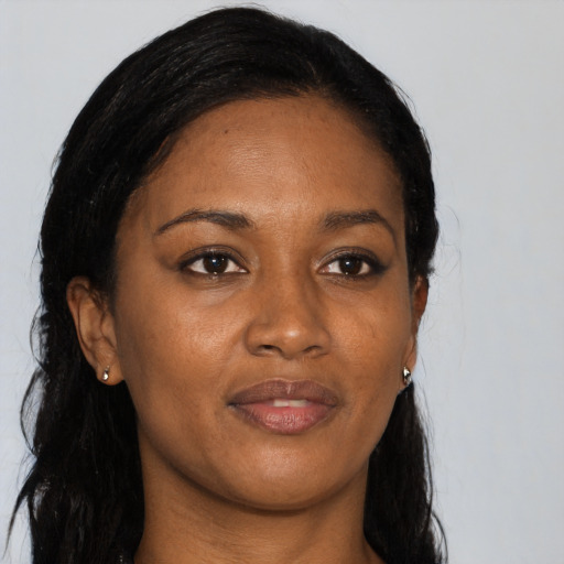 Joyful black young-adult female with long  black hair and brown eyes
