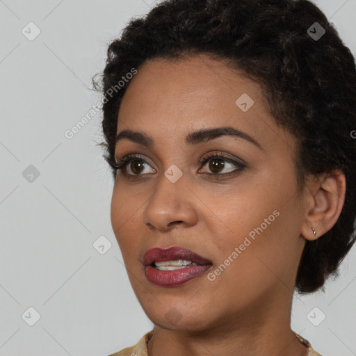 Joyful black young-adult female with short  black hair and brown eyes