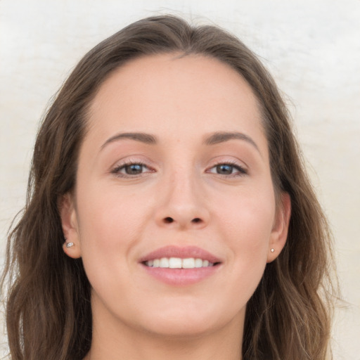 Joyful white young-adult female with long  brown hair and grey eyes