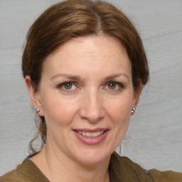 Joyful white adult female with medium  brown hair and grey eyes