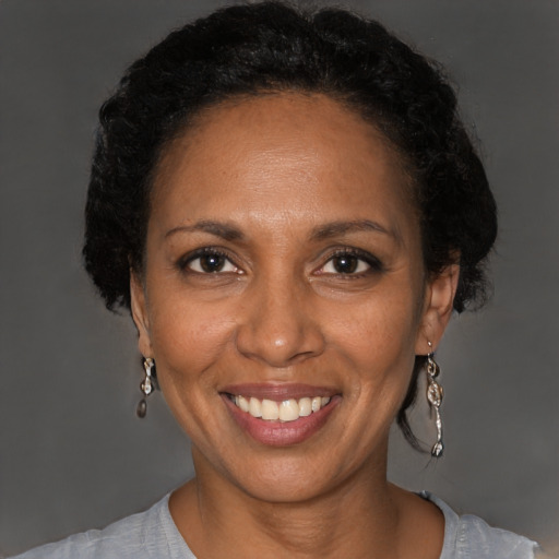 Joyful black adult female with short  brown hair and brown eyes