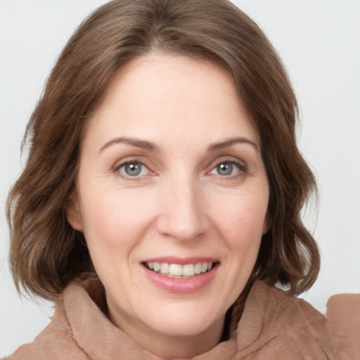 Joyful white young-adult female with medium  brown hair and grey eyes