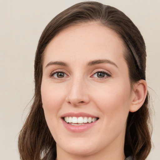 Joyful white young-adult female with long  brown hair and green eyes