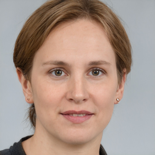 Joyful white young-adult female with medium  brown hair and grey eyes