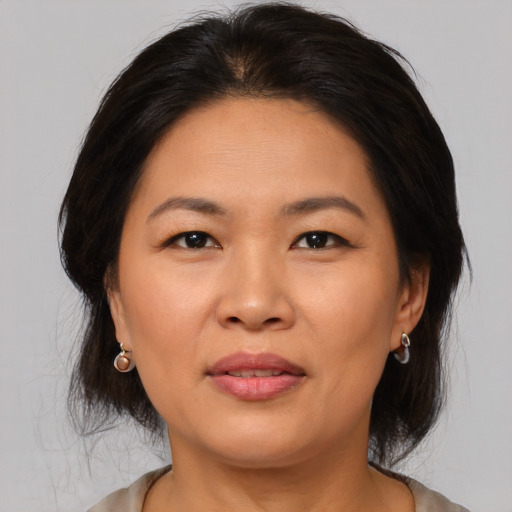 Joyful asian adult female with medium  brown hair and brown eyes