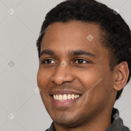 Joyful black young-adult male with short  black hair and brown eyes