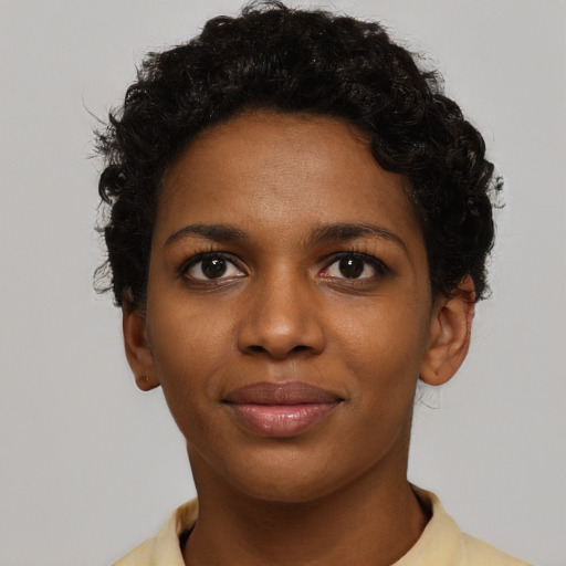 Joyful black young-adult female with short  black hair and brown eyes