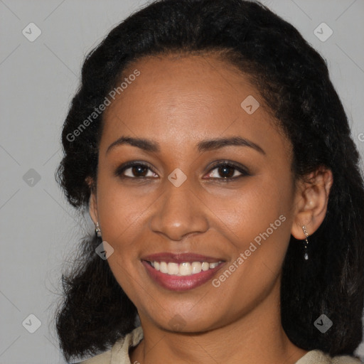 Joyful black young-adult female with long  black hair and brown eyes