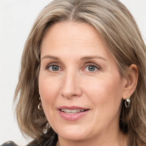 Joyful white adult female with medium  brown hair and grey eyes