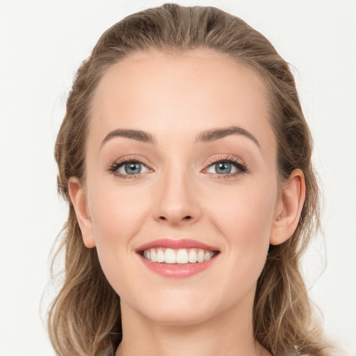 Joyful white young-adult female with long  brown hair and blue eyes