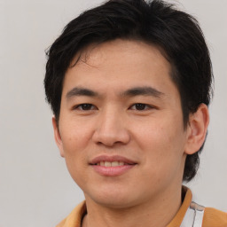 Joyful asian young-adult male with short  brown hair and brown eyes