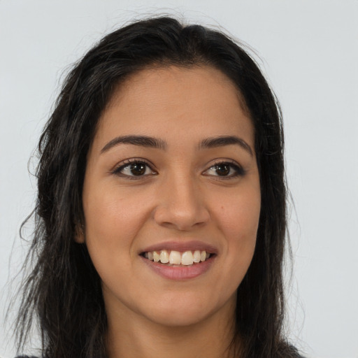 Joyful latino young-adult female with long  brown hair and brown eyes