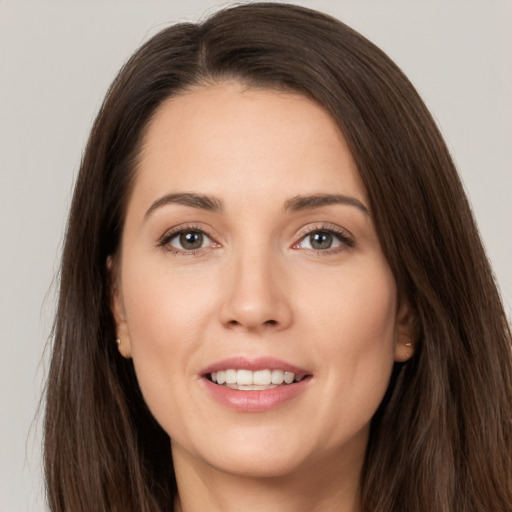 Joyful white young-adult female with long  brown hair and brown eyes