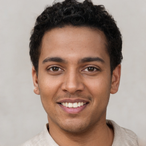 Joyful latino young-adult male with short  brown hair and brown eyes