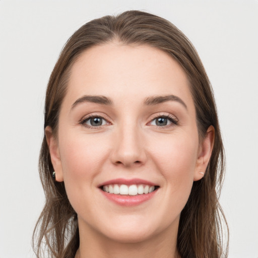 Joyful white young-adult female with long  brown hair and grey eyes