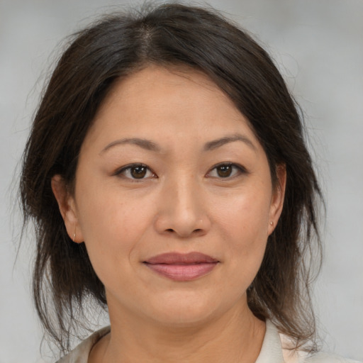 Joyful asian adult female with medium  brown hair and brown eyes