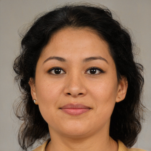 Joyful latino adult female with medium  brown hair and brown eyes