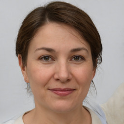 Joyful white adult female with medium  brown hair and grey eyes