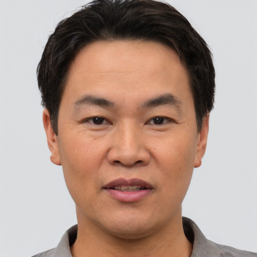 Joyful asian adult male with short  black hair and brown eyes