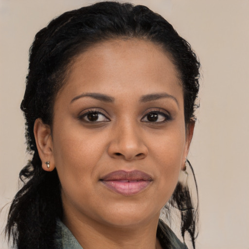 Joyful black young-adult female with long  brown hair and brown eyes