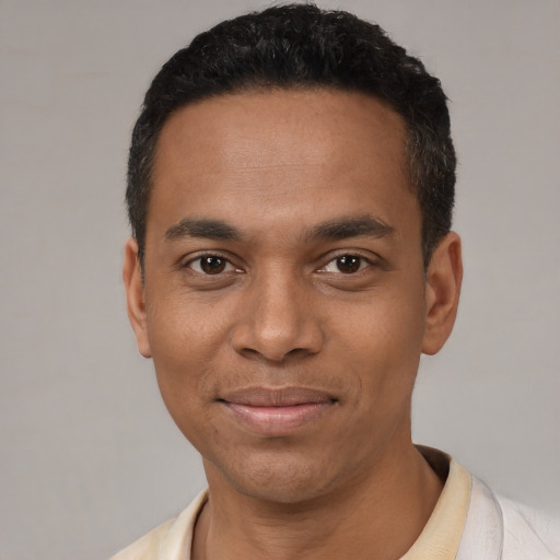 Joyful black young-adult male with short  black hair and brown eyes