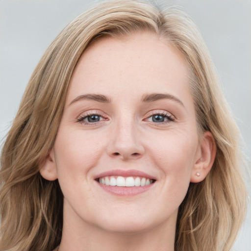 Joyful white young-adult female with long  brown hair and blue eyes