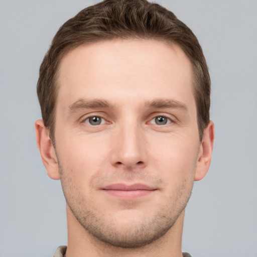 Joyful white young-adult male with short  brown hair and grey eyes