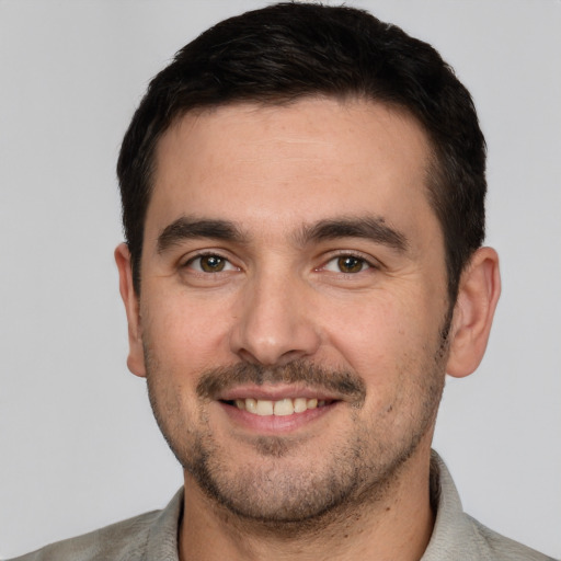 Joyful white young-adult male with short  black hair and brown eyes