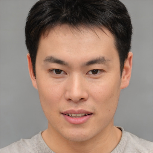Joyful asian young-adult male with short  brown hair and brown eyes