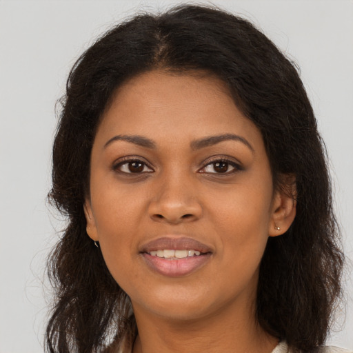 Joyful black young-adult female with long  brown hair and brown eyes