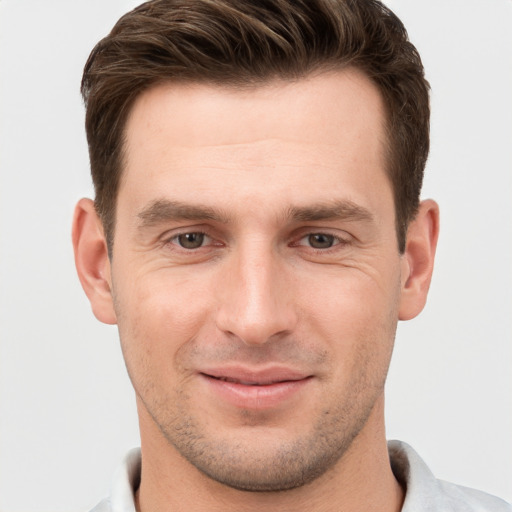 Joyful white young-adult male with short  brown hair and grey eyes