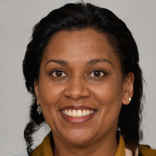 Joyful black adult female with long  brown hair and brown eyes