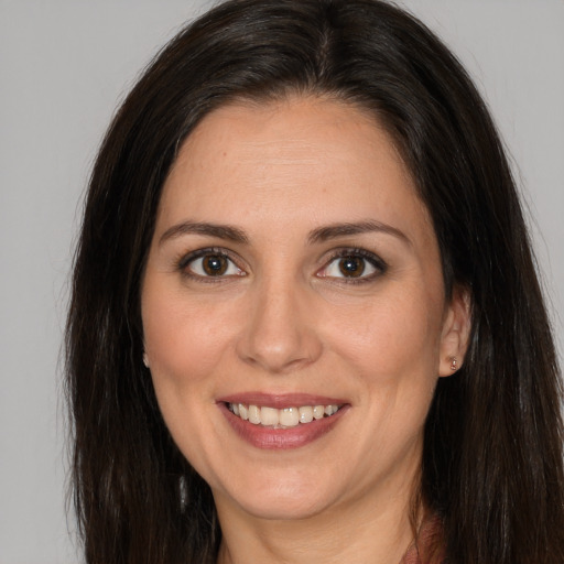 Joyful white adult female with long  brown hair and brown eyes