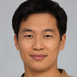 Joyful asian young-adult male with short  brown hair and brown eyes