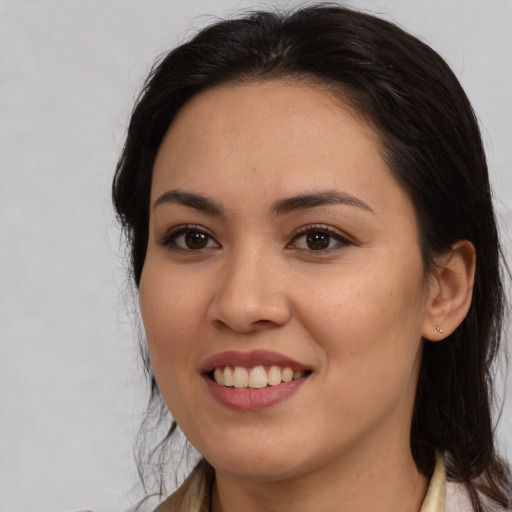 Joyful latino young-adult female with medium  brown hair and brown eyes