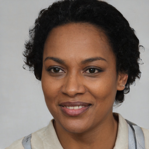 Joyful black young-adult female with short  black hair and brown eyes