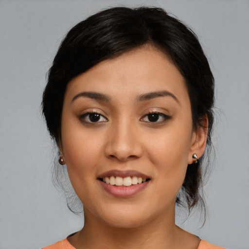 Joyful latino young-adult female with medium  brown hair and brown eyes