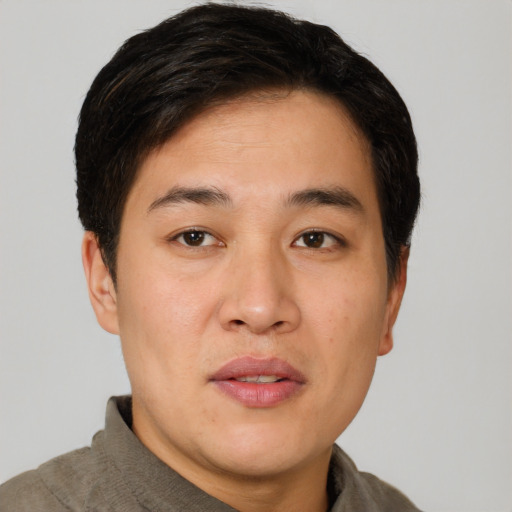 Joyful asian young-adult male with short  brown hair and brown eyes