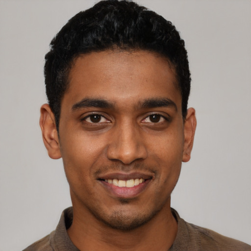 Joyful latino young-adult male with short  black hair and brown eyes