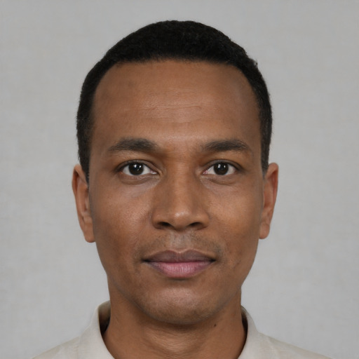 Joyful black young-adult male with short  black hair and brown eyes